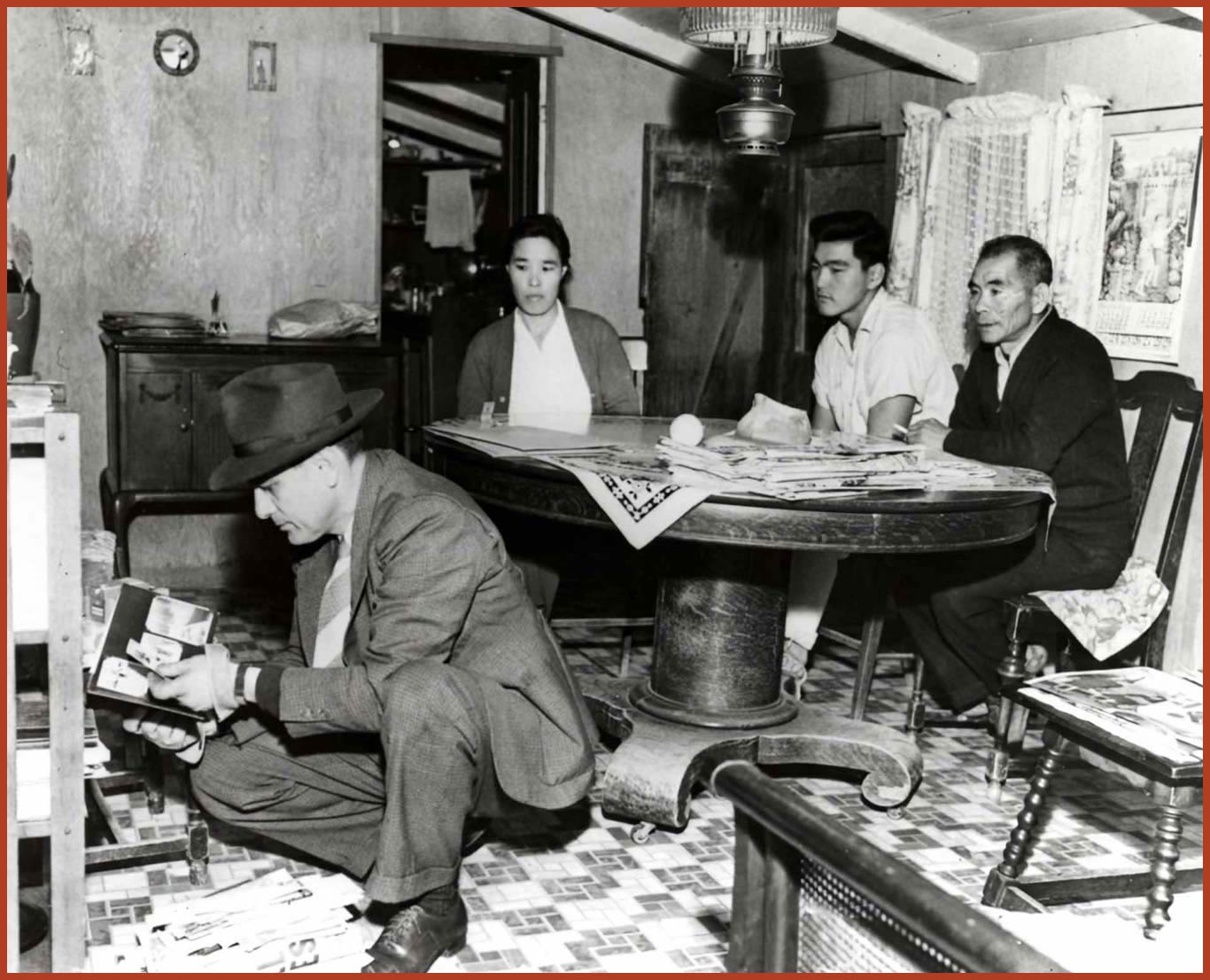An FBI agent searches the home of a Japanese American family.