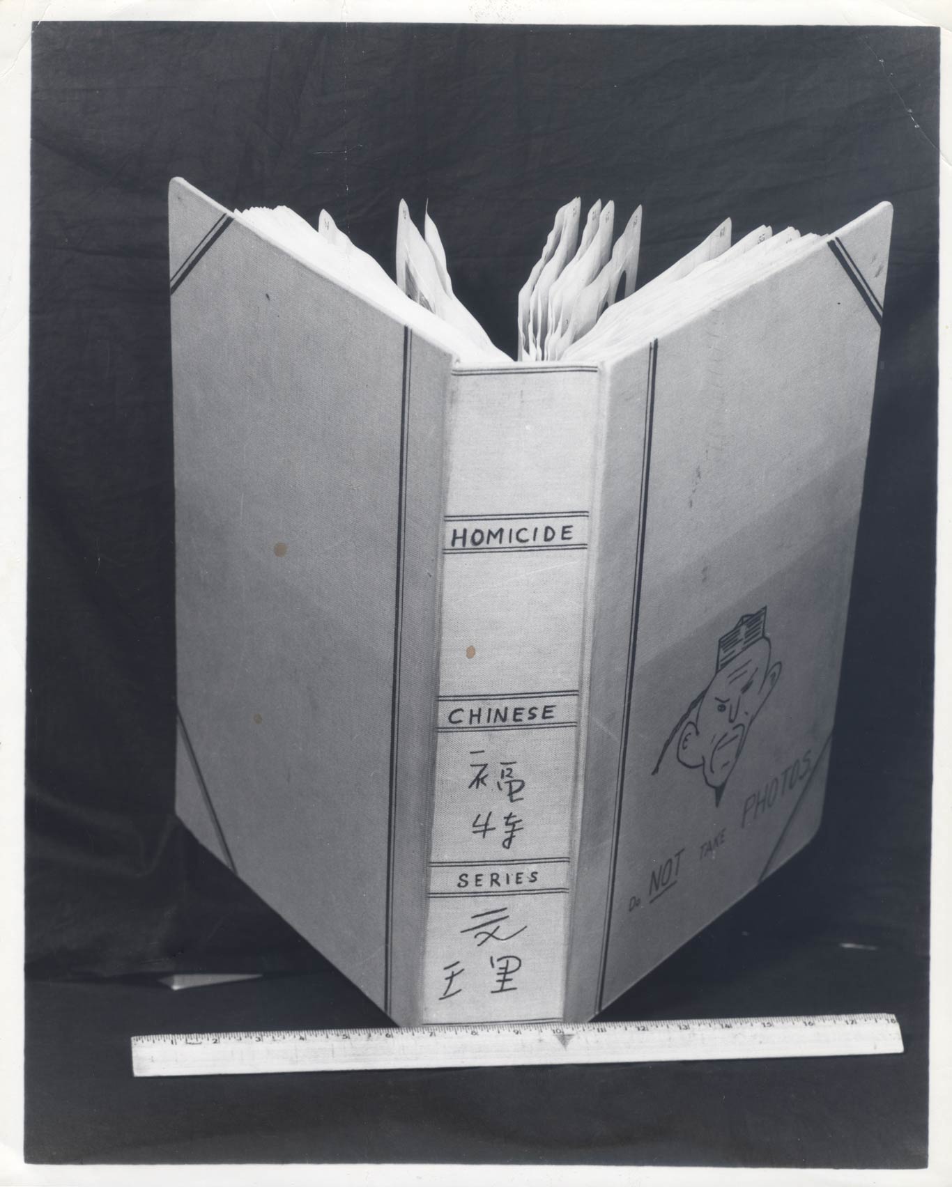 Photo of a book propped open. Spine of book reads ""Homocide Chinese Series."" Cover of book reads ""Do Not take Photos.""