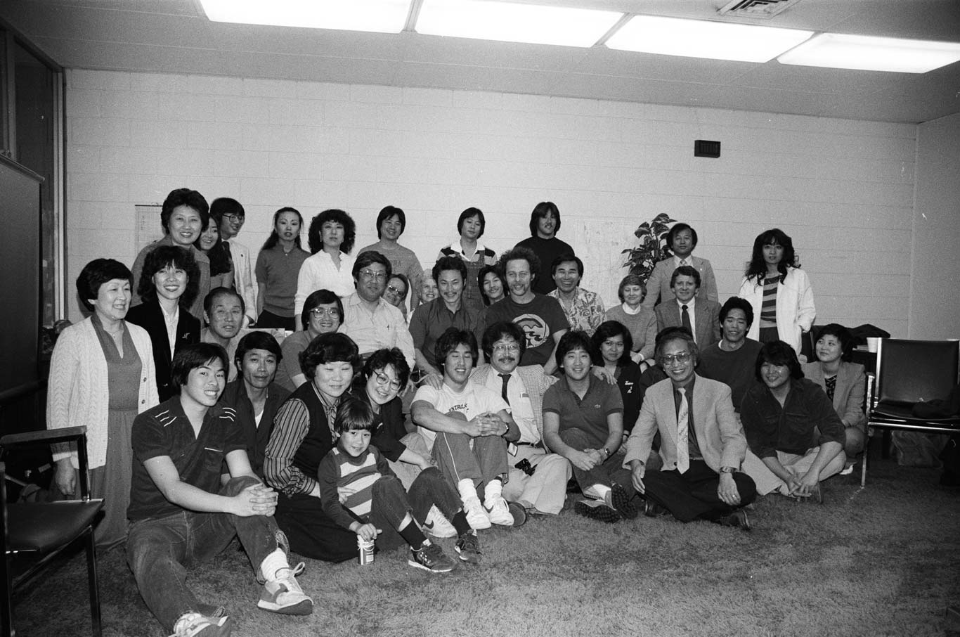 Chol Soo Lee sits with a large group of individuals. All smile towards the camera.