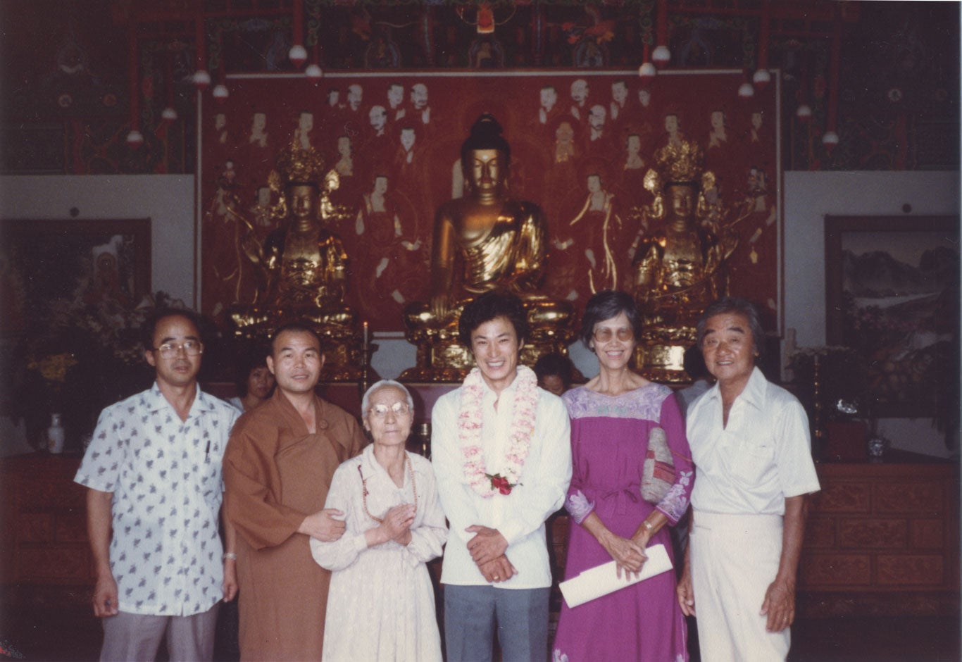 Chol Soo Lee stands with a few people in a Buddhist temple.