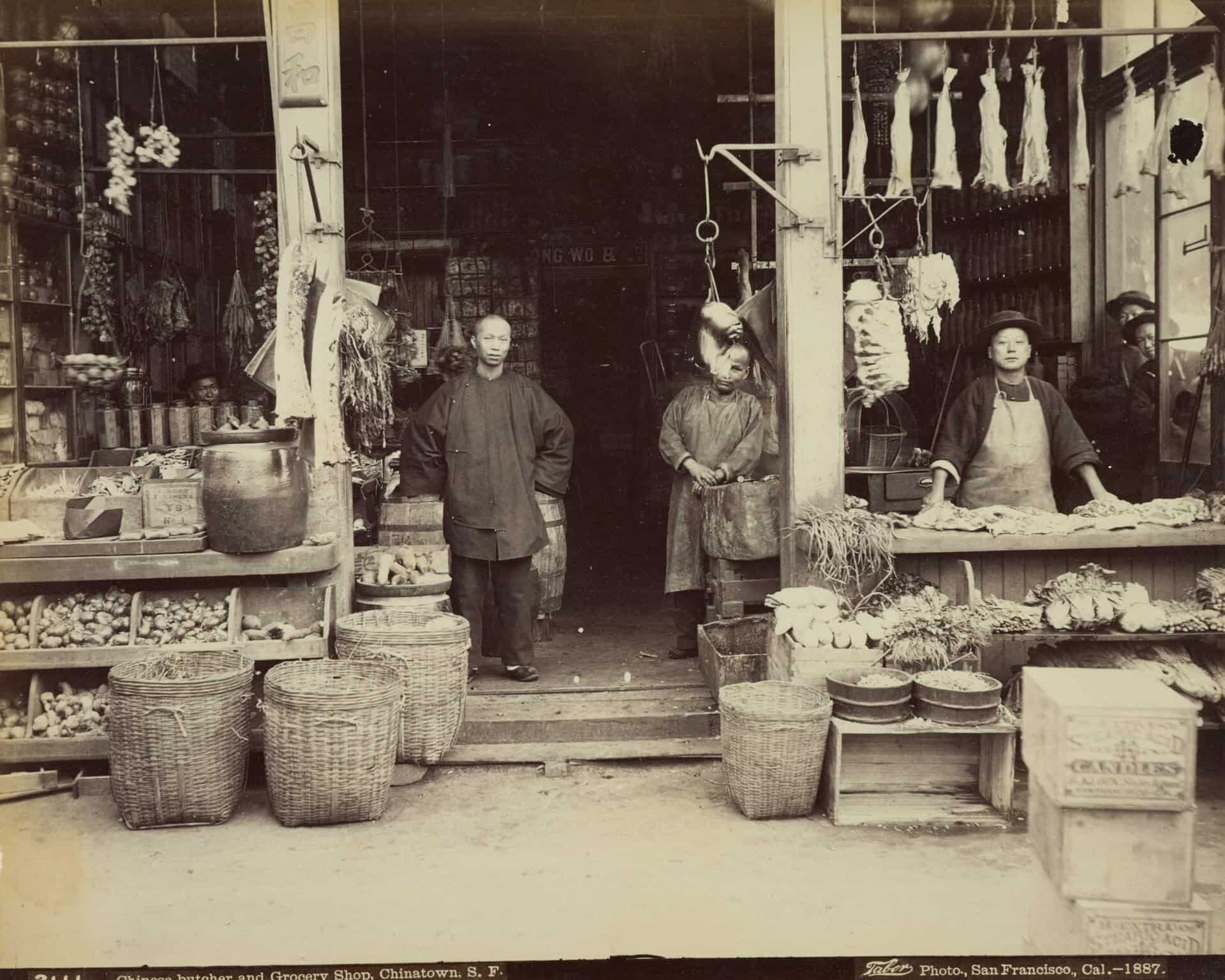 Chinese vendors with queue hairstyle and wearing shanku waiting for customers to visit their grocery store and butchery in Chinatown.