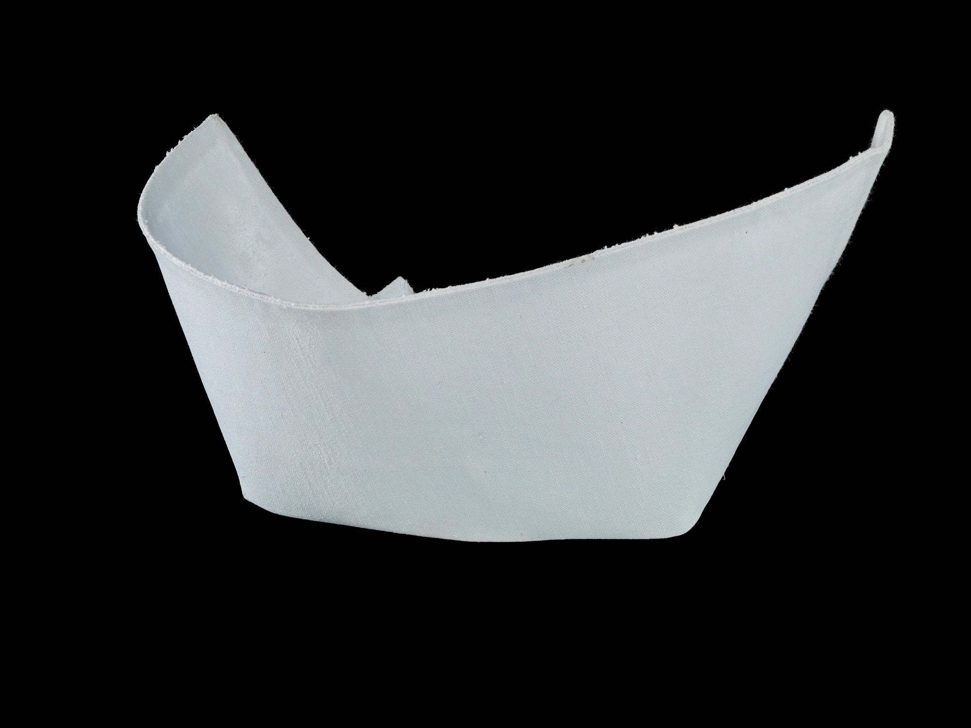 Exhibit photo of a white cotton crescent-shaped nursing cap against a black background.