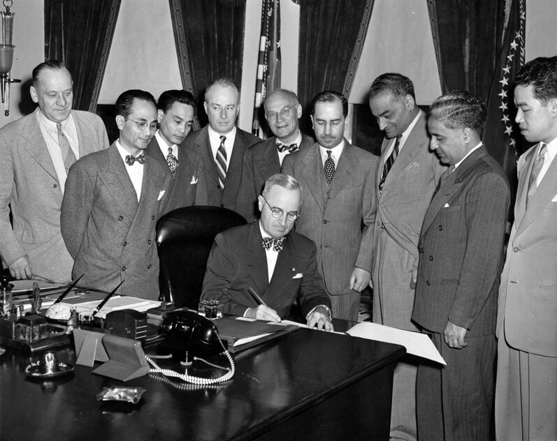 Sikh merchant Jagjit Singh stands alongside U.S. government officials witnessing a seated President Truman as he signs the Luce-Celler Act of 1946.