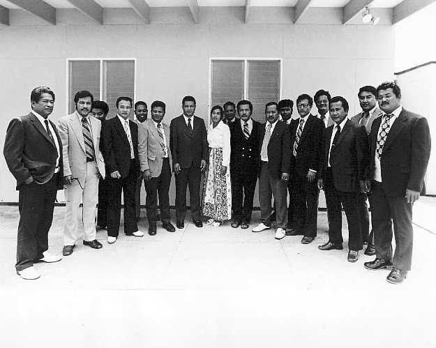 Members of the Federated States of Micronesia's Congress, a group of men and one woman, all in professional attire, stand in a row for indoor photo.