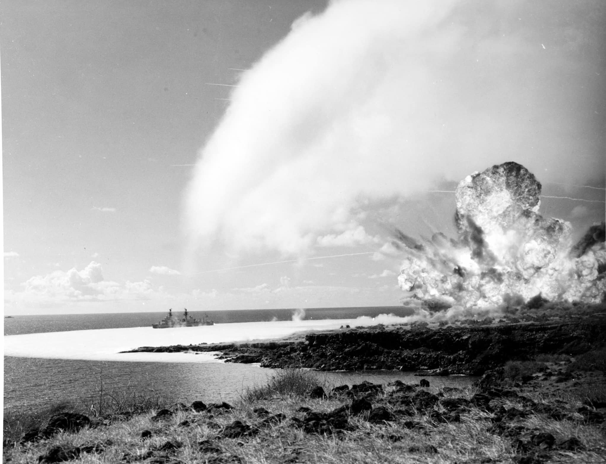 A condensation cloud forms above the detonation of 500-tons of TNT on Kaho‘olawe. A shockwave spreads over the water towards a U.S. Navy test ship.