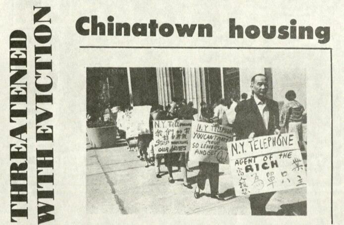 Rows of people with signs protest outside of building.