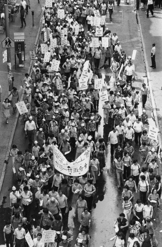 Aerial view of street filled with marchers carrying signs and banners.