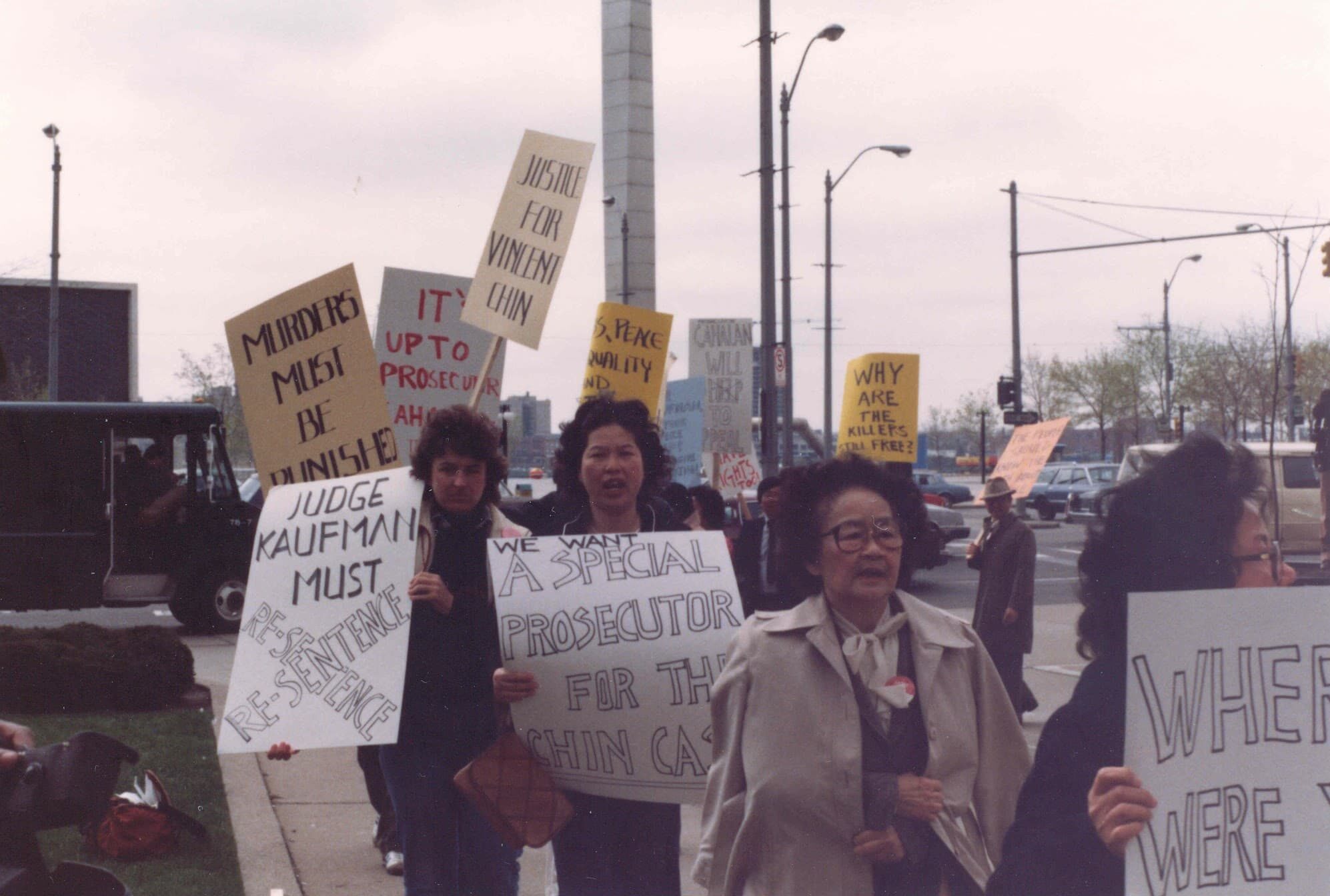 Group of people picket on sidewalk in front of courthouse with signs related to justice for Vincent Chin.