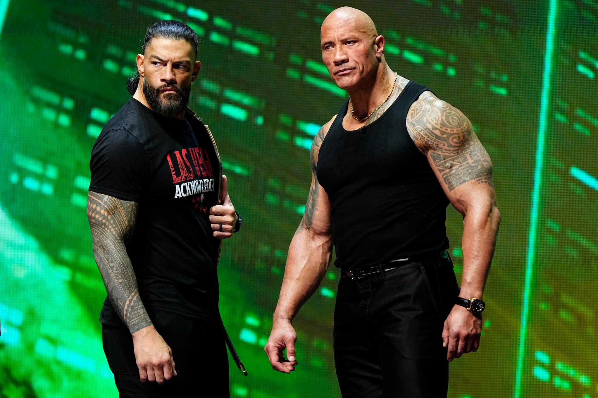 Dressed casually, wrestlers Leati Joseph Anoaʻi, known as Roman Reigns (left), and Dwayne "The Rock" Johnson (right) pose together at WrestleMania.