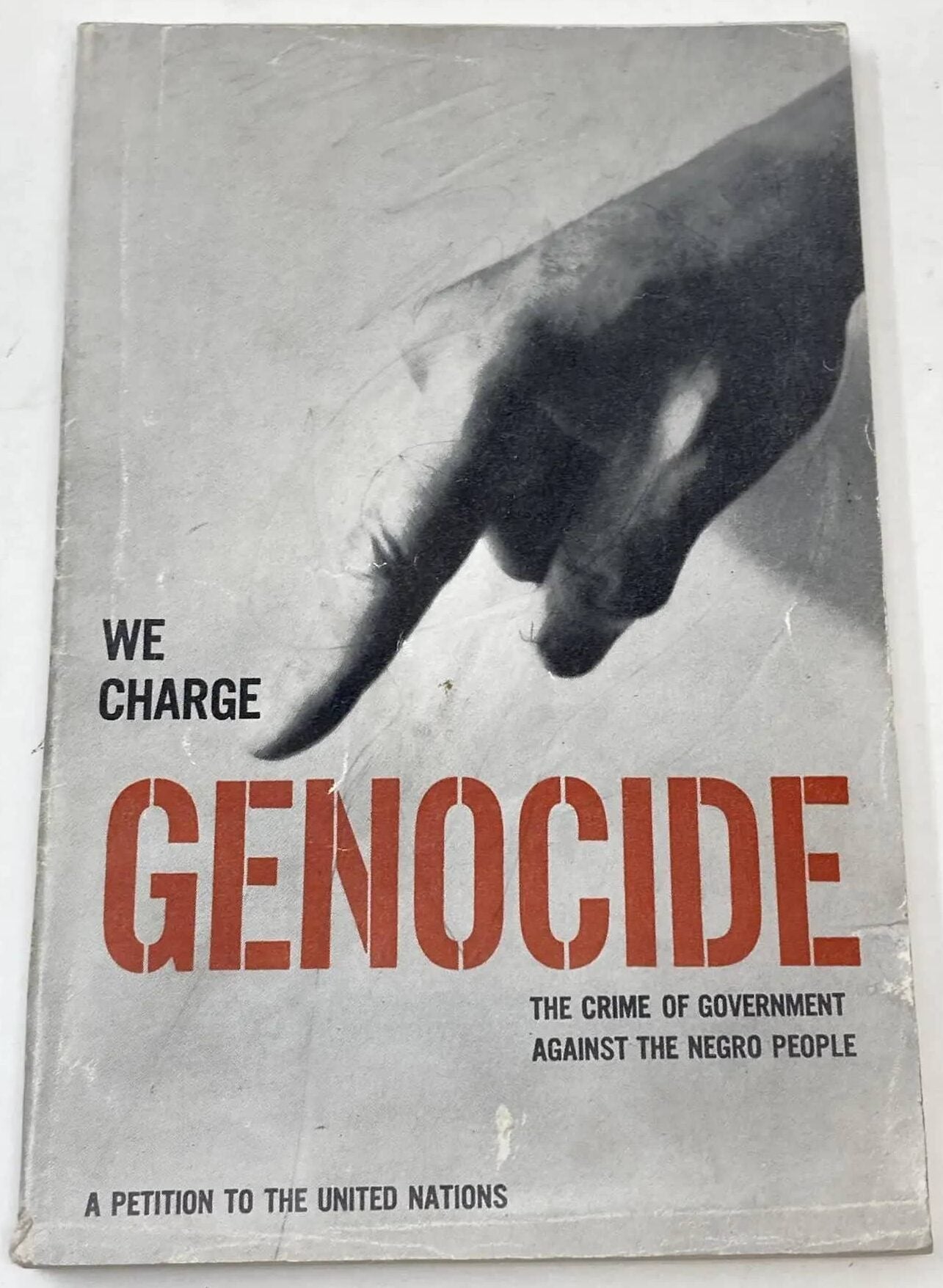 The cover of We Charge Genocide, a petition to the United Nations. A hand points at the word "Genocide" from the title.