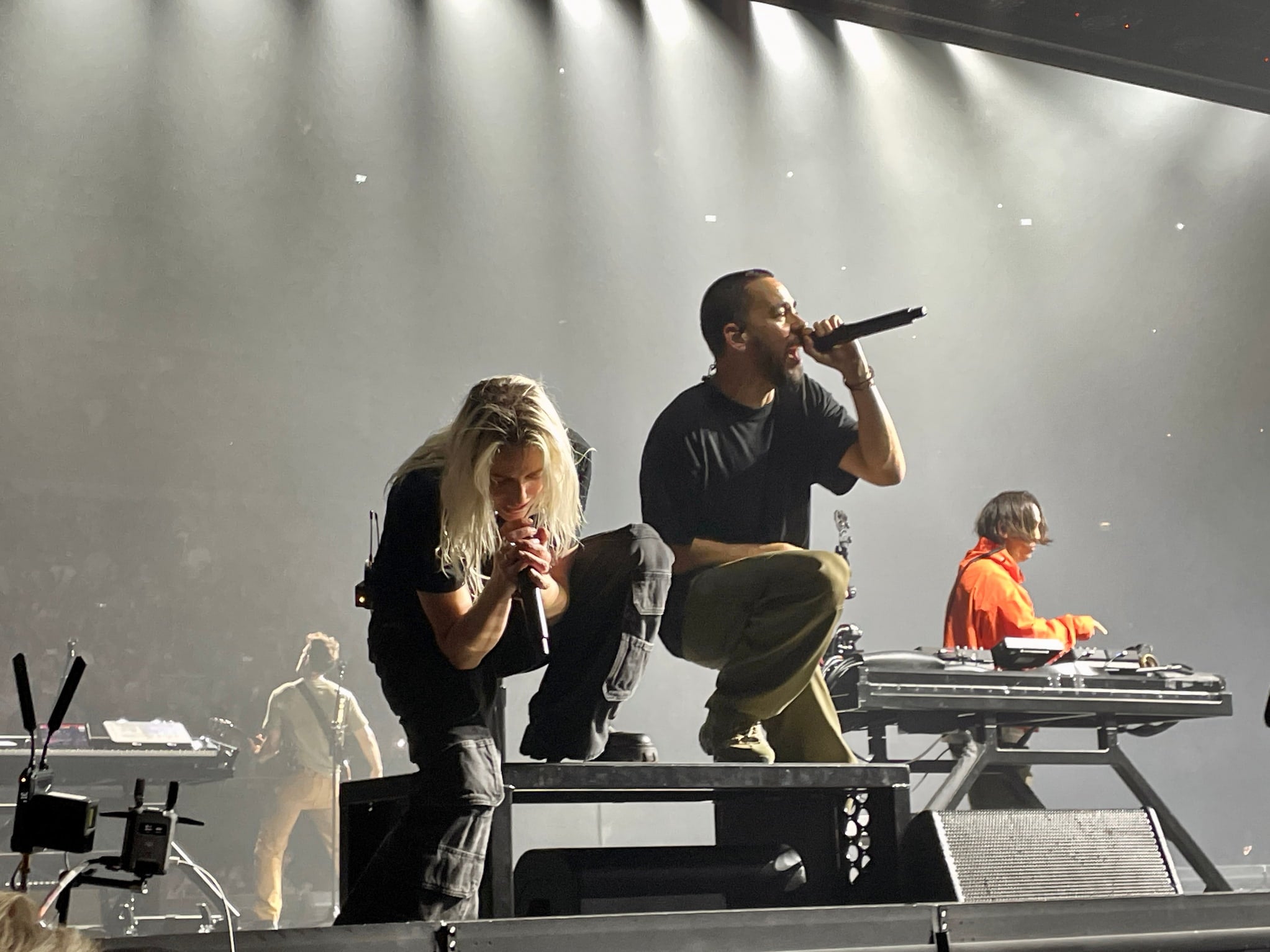Vocalist Emily Armstrong (left), rapper Mike Shinoda (center) and DJ Joe Hahn (right) perform on stage at indoor arena.