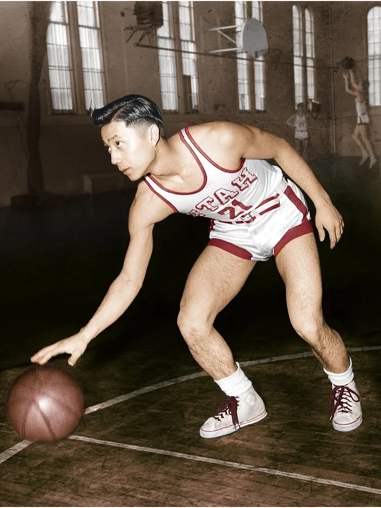 Wat Misaka, a Japanese American man wearing a University of Utah tank and basketball shorts, dribbles ball on court.