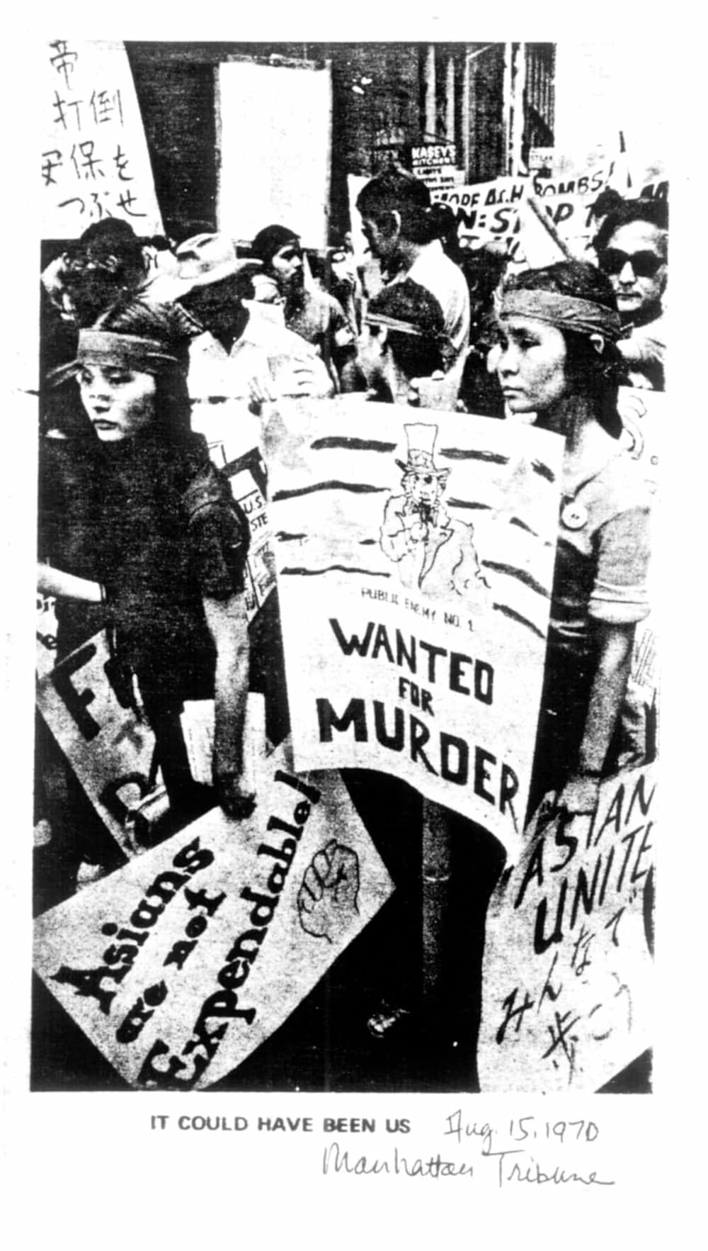Siblings Audee, Aichi, and Billy Kochiyama hold signs among crowd of anti-war demonstrators. Caption reads, "It Could Have Been Us."
