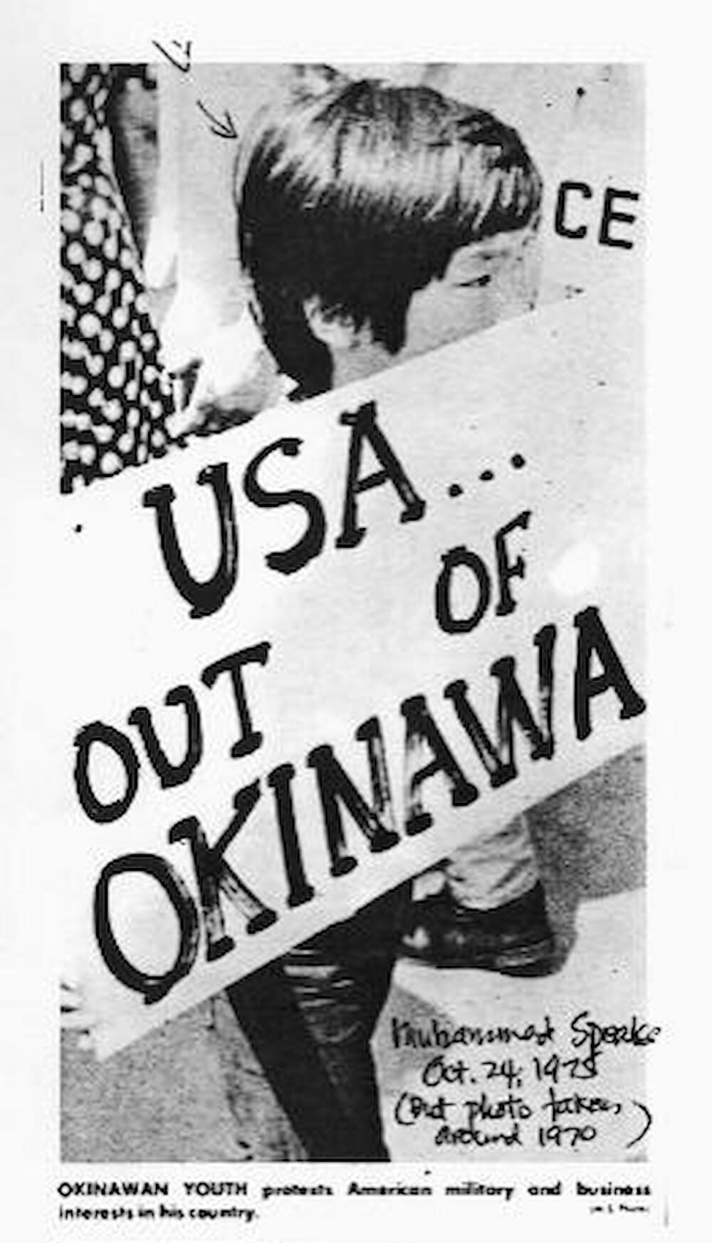 Japanese American boy Tommy Kochiyama holds a large sign in front of him that reads, "USA...Out of Okinawa" at a rally against U.S. military bases.