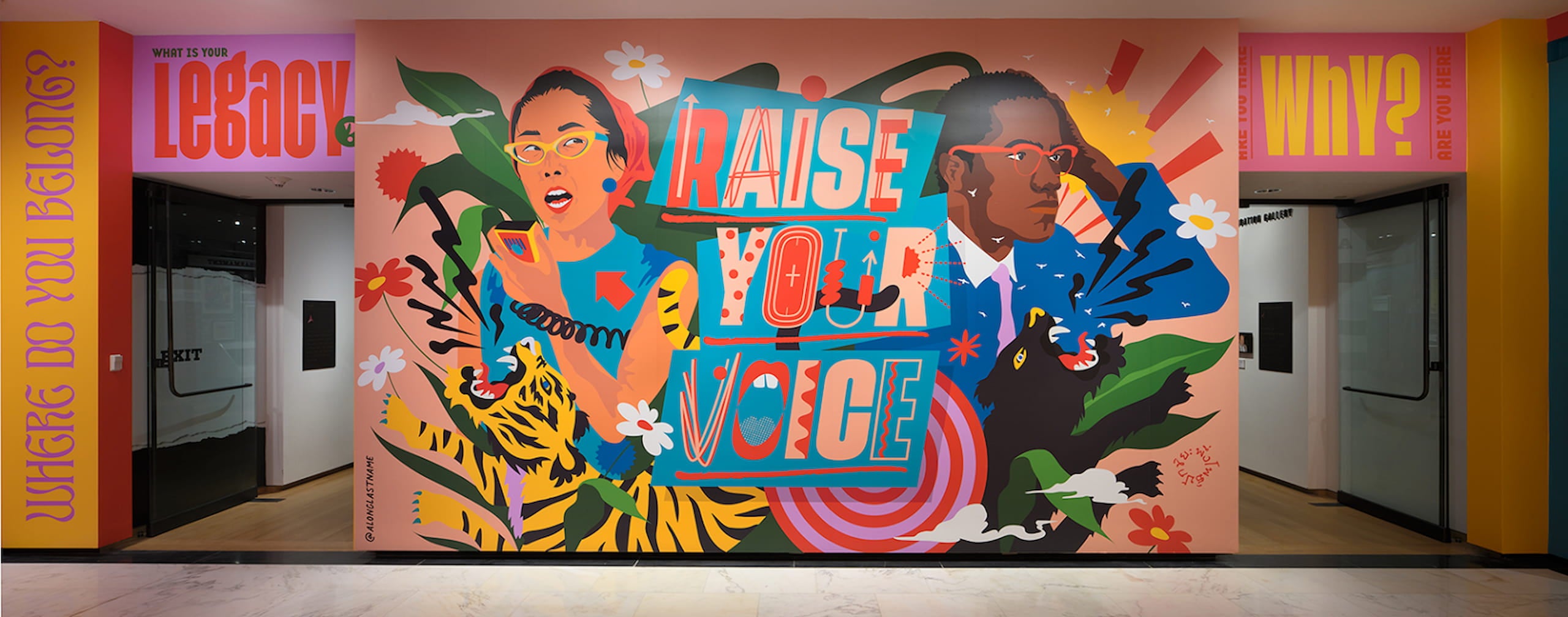 Photo of indoor mural with drawings of Yuri Kochiyama and Malcolm X. A tiger and a panther roaring are placed front of Yuri and Malcolm X.