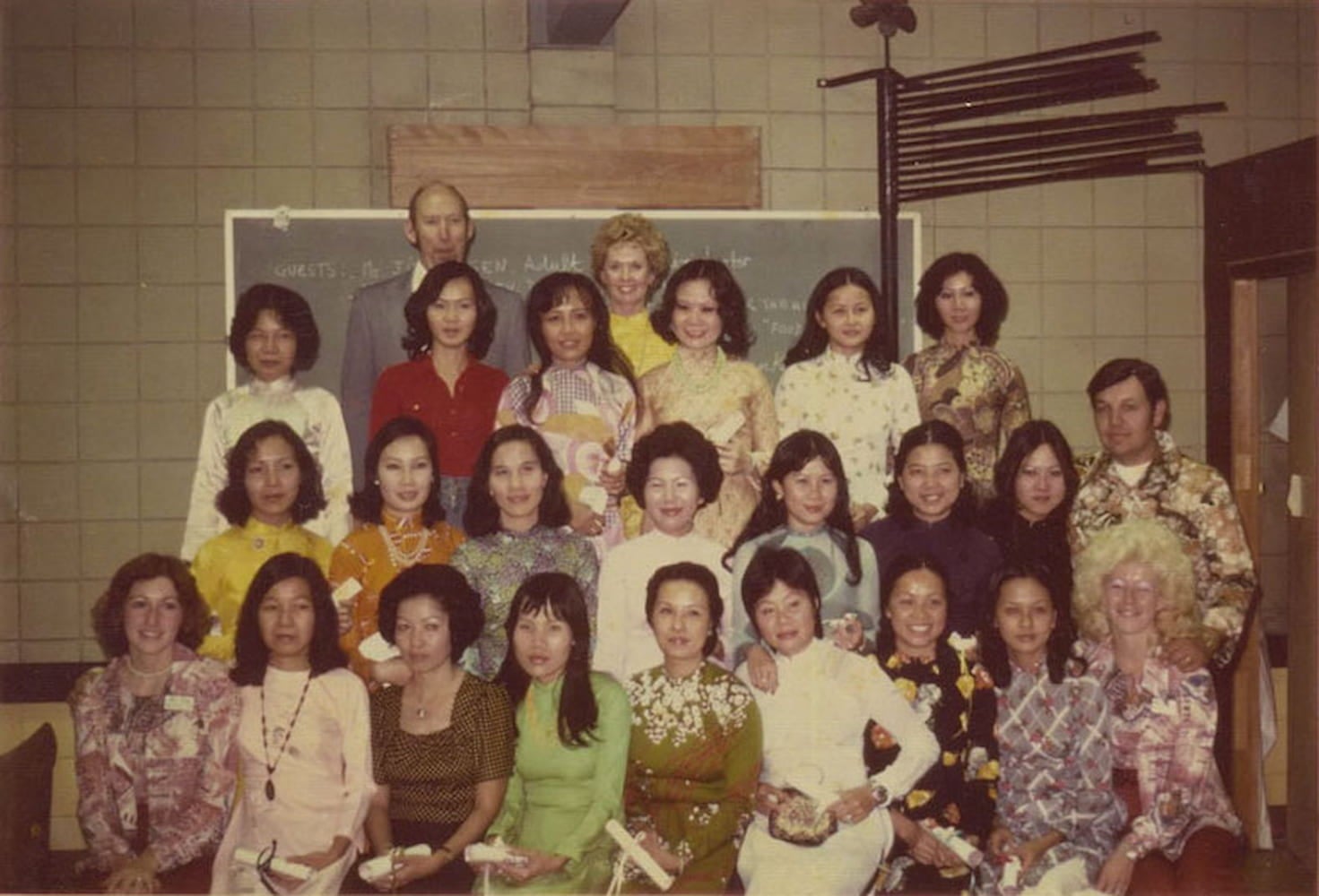 A group of Vietnamese and white women pose for a class photo. In the top center is Vietnamese American Tippi Hedren.