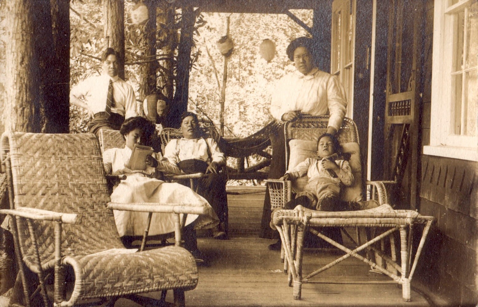 Joseph (in rocker), Gertrude (reading), Robert Park (on rail), Emily Park and son Frank sit on the porch of the Tape Family summer home.