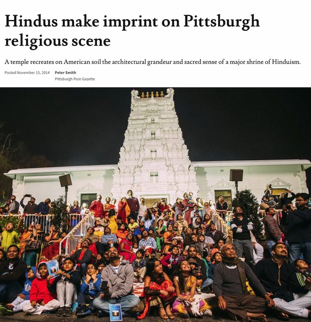 Devotees sit on steps in front of the Sri Venkateswara Temple all looking up at the fireworks show.