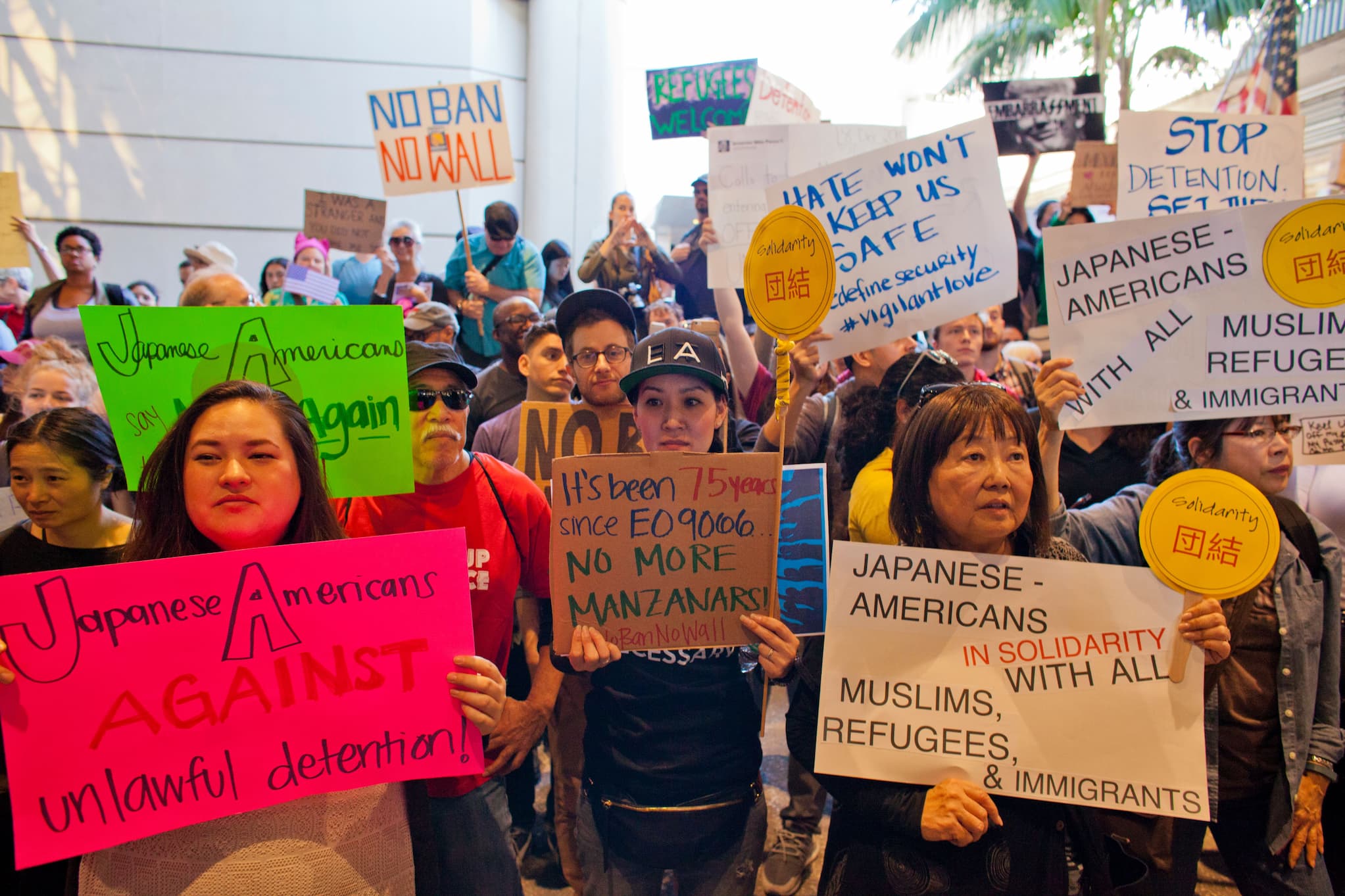 A protest at Los Angeles International Airport against the Muslim ban, with Japanese Americans at the forefront with signs that reads solidarity with refugees.