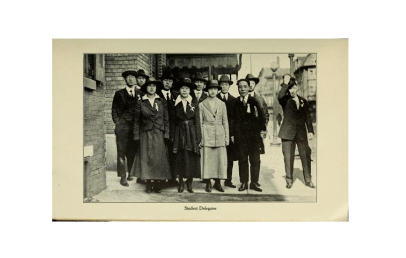 Photo titled student delegates: Women and men dressed in suits and hats posing on a city sidewalk.