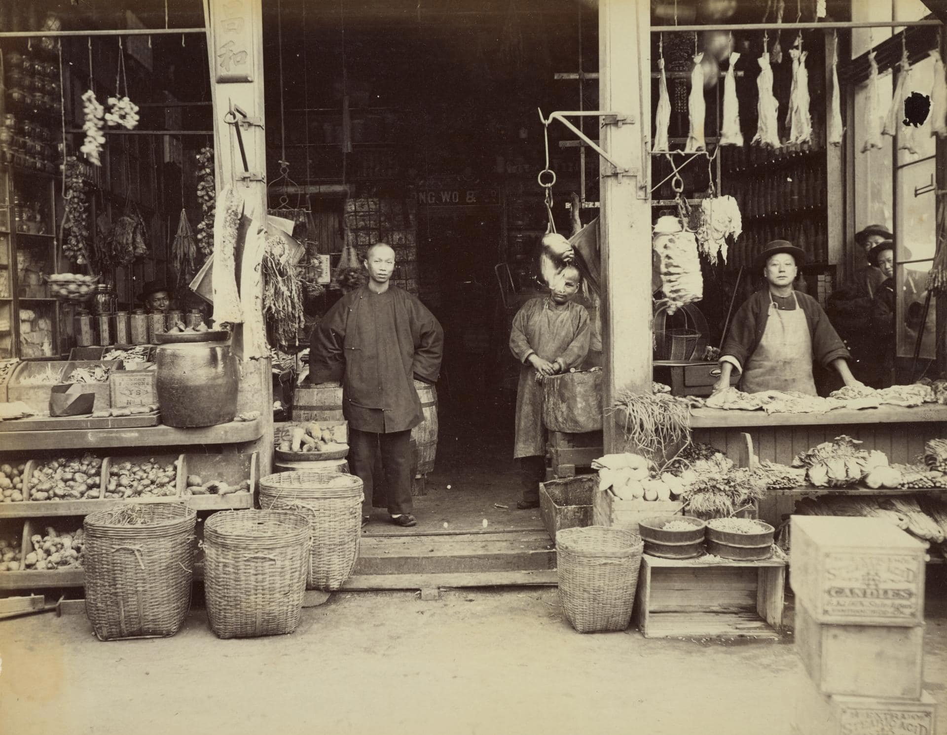 Chinese vendors with queue hairstyle and wearing shanku waiting for customers to visit their grocery store and butchery in Chinatown.