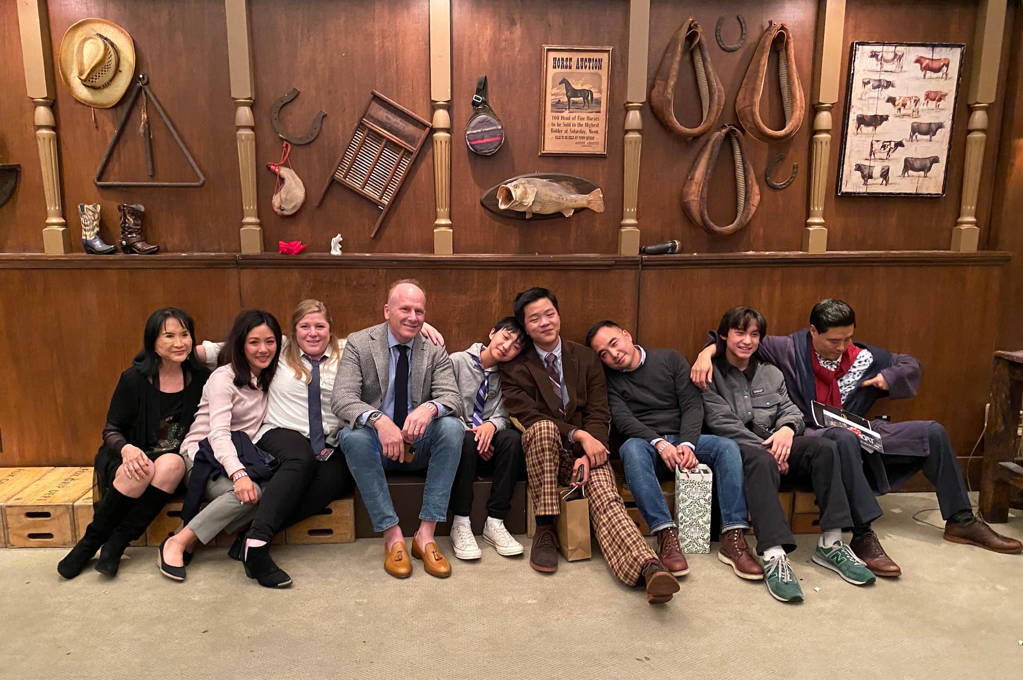 Fresh Off The Boat's cast and crew lean against one another as they sit on the floor of indoor set and smile for group photo.
