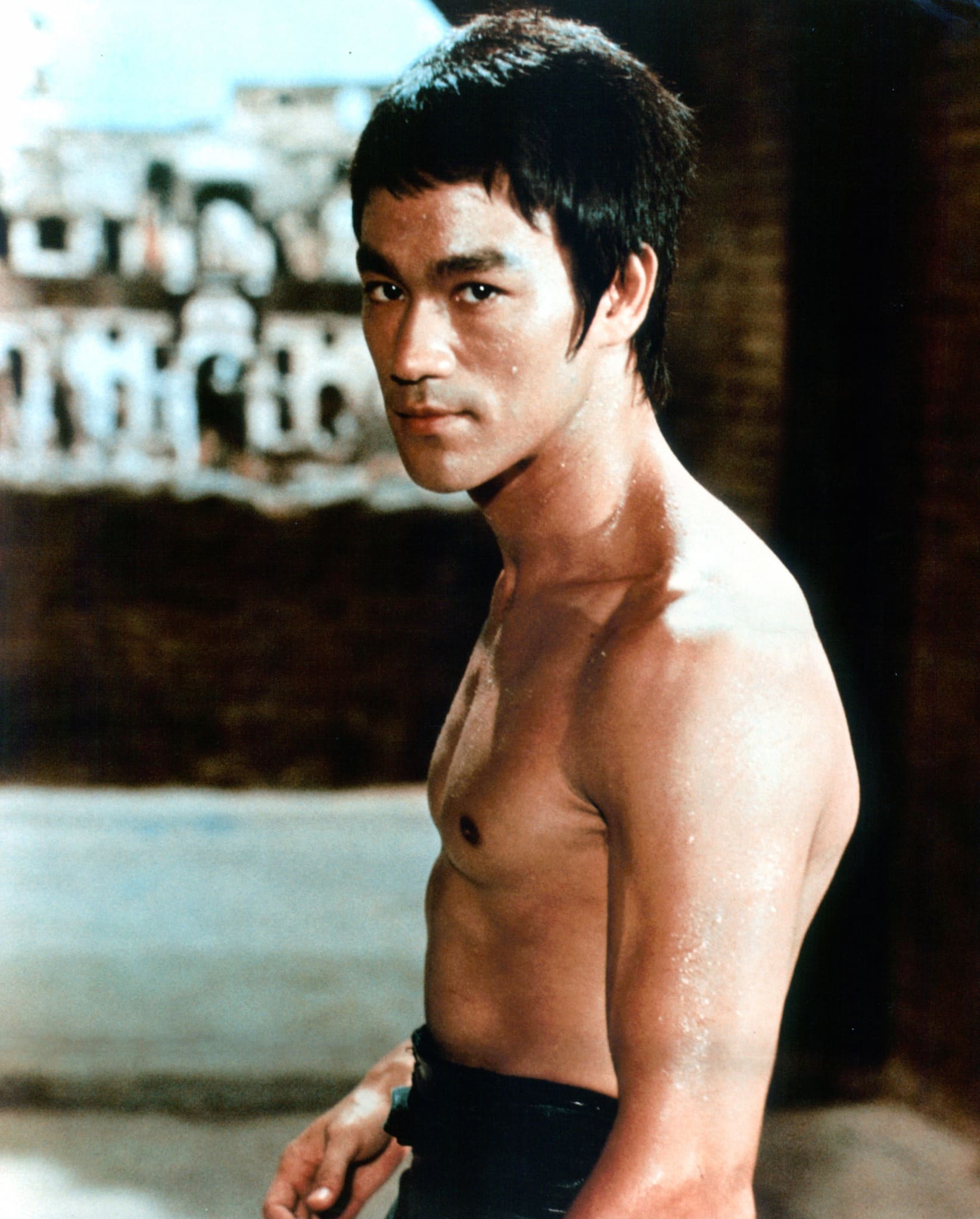 Martial artist and actor Bruce Lee, a Hong Kong-American man, stands shirtless for publicity portrait.