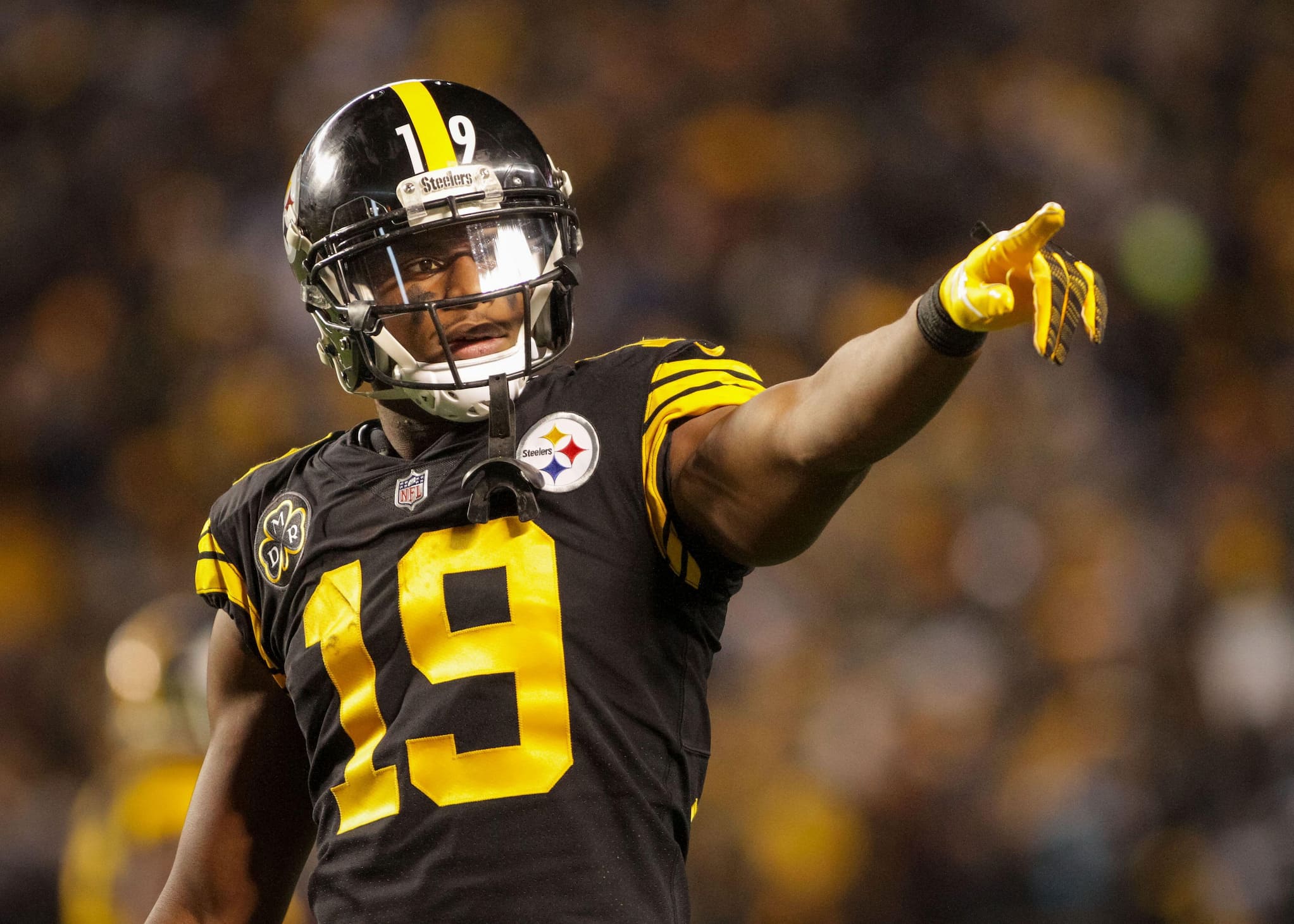 Pittsburgh Steeler Juju Smith pointing to the crowd during a game. His face shows a determined expression.