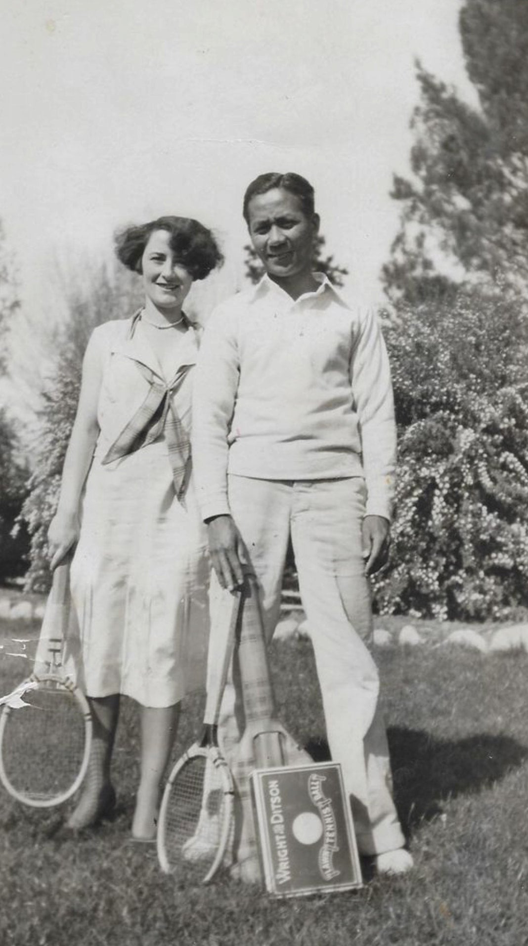 Salvador Roldan and Marjorie Rogers pose in their tennis outfits while holding rackets.