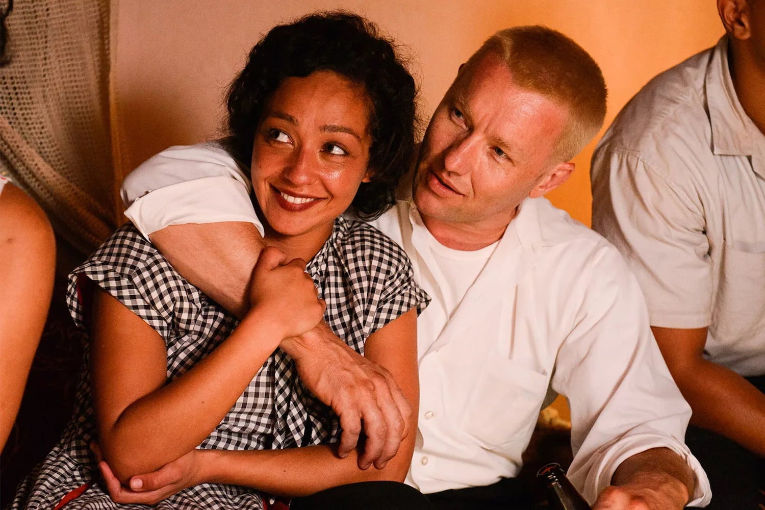 Actors recreate a photo of Mildred and Richard. She smiles and holds his forearm as he drapes his arm over her shoulder and across her chest.
