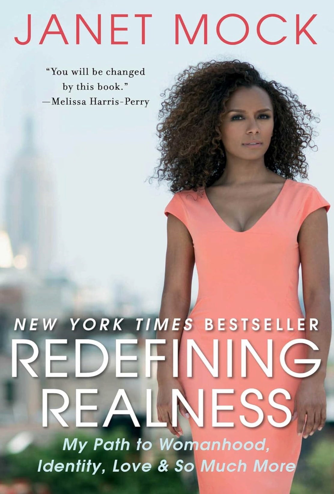 The book cover for Redefining Realness shows Janet Mock in a peach dress with a serious expression. The city backdrop is blurred.