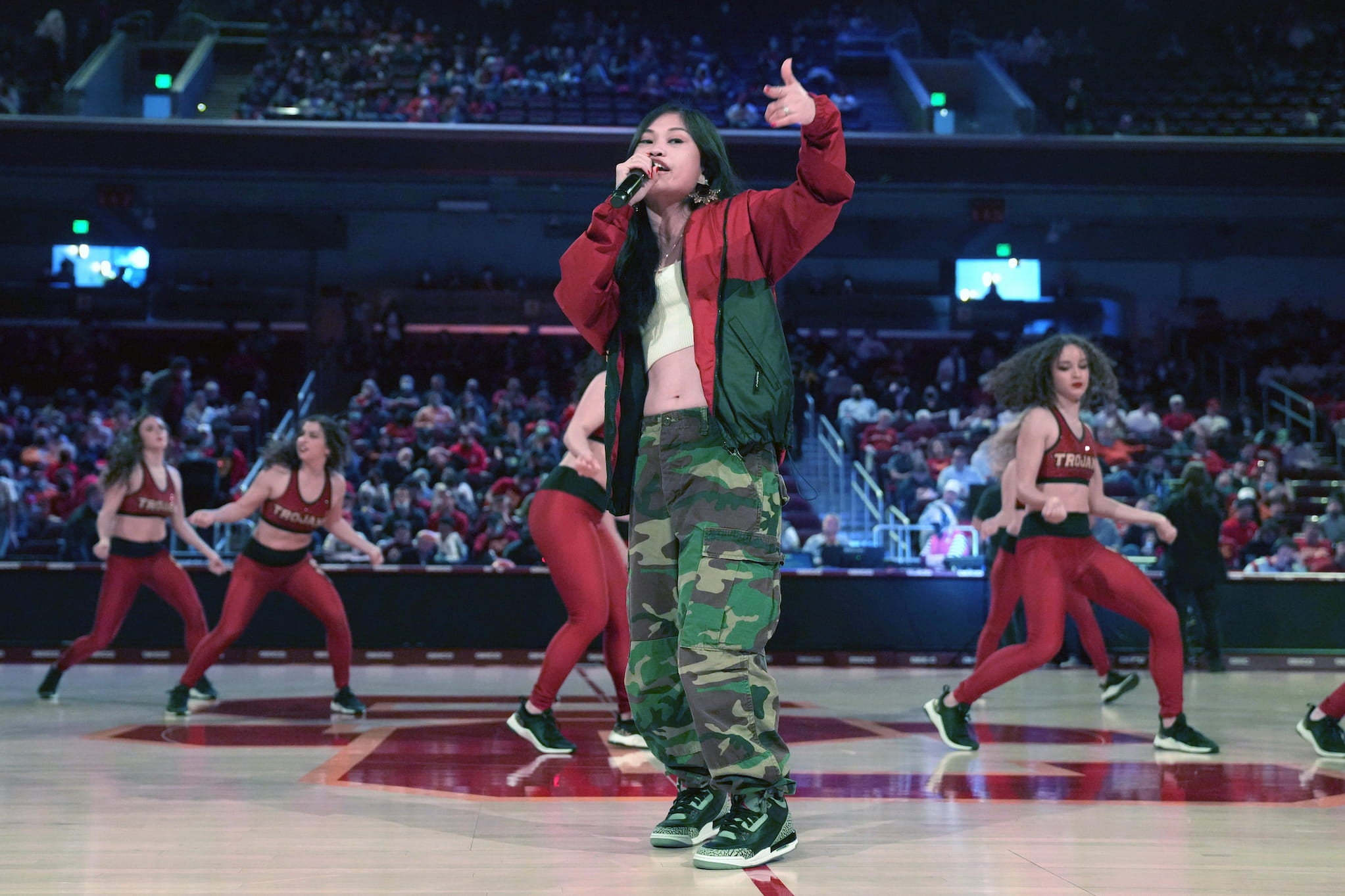 Ruby Ibarra rapping in an auditorium with dancers behind her.