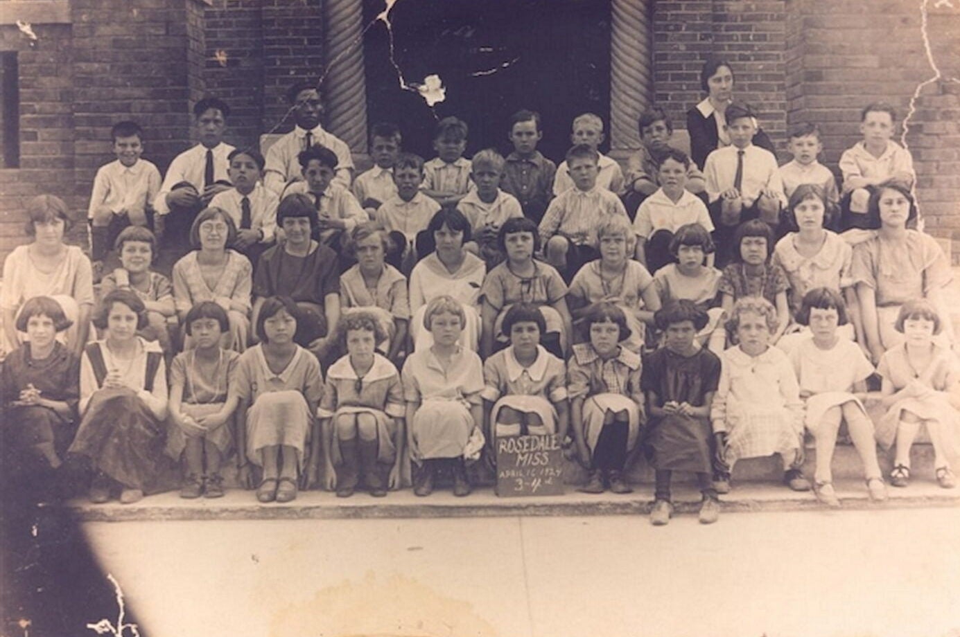 Faded second-grade class photo of Martha Lum in an otherwise all-white class.