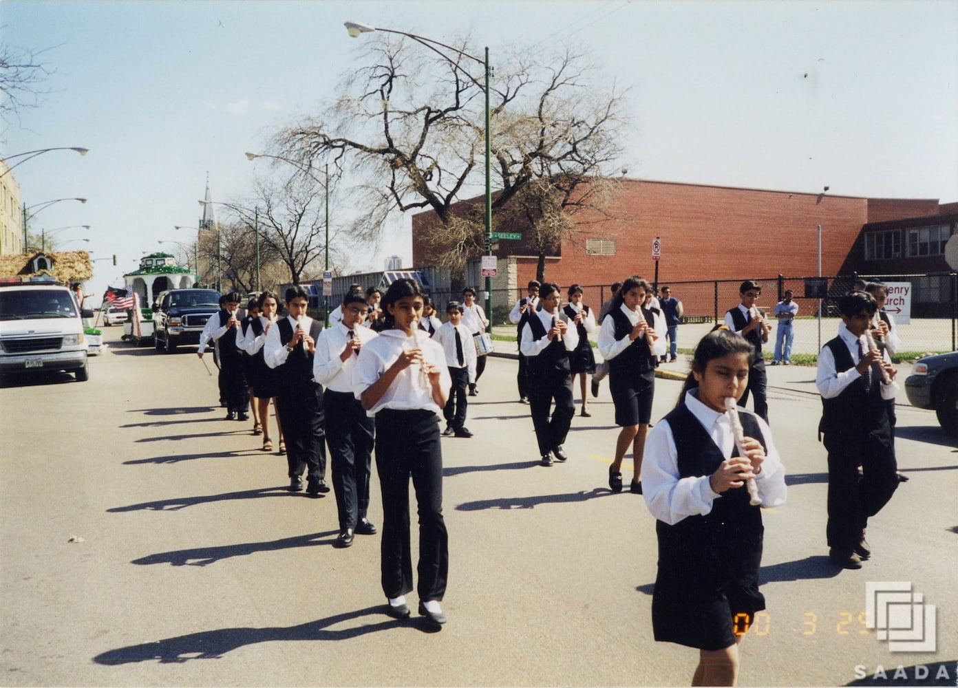 The Ismaili Muslim Youth Marching Band in uniforms march down Devon Avenue in Chicago while playing recorders and drums for the parade.