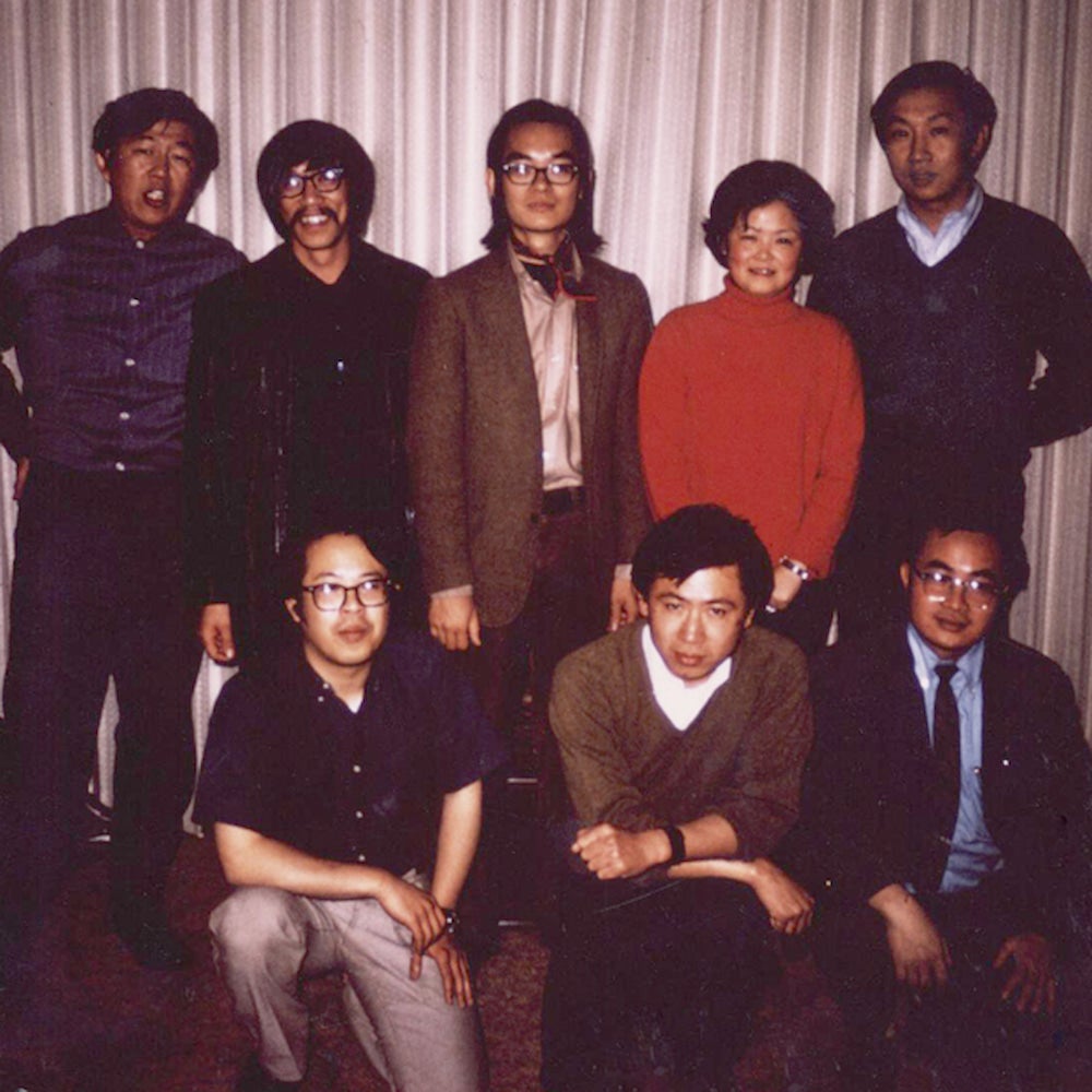 Asian American Studies faculty members pose in front of a curtain.