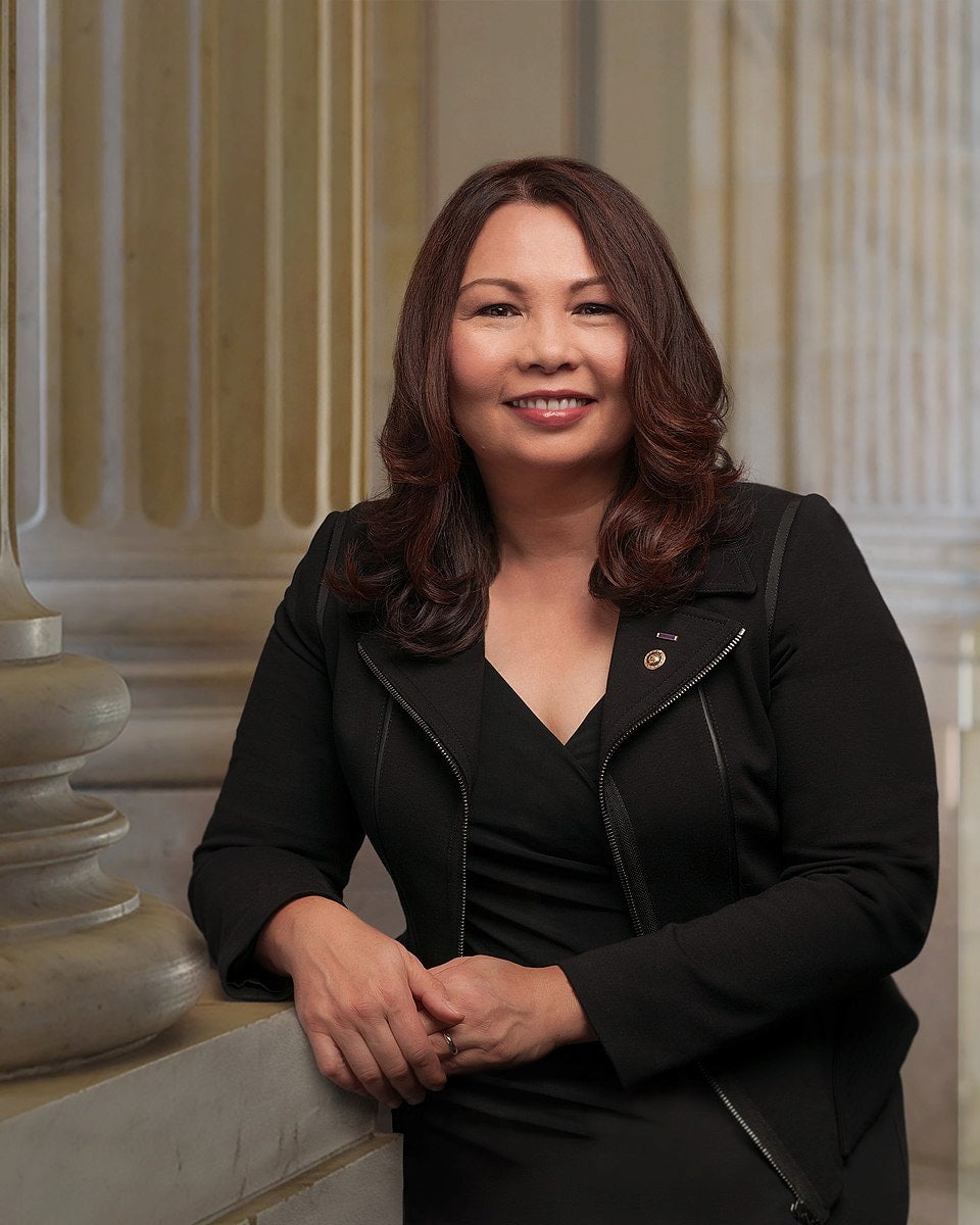 Formal portrait of Tammy Duckworth with pillars as a background.