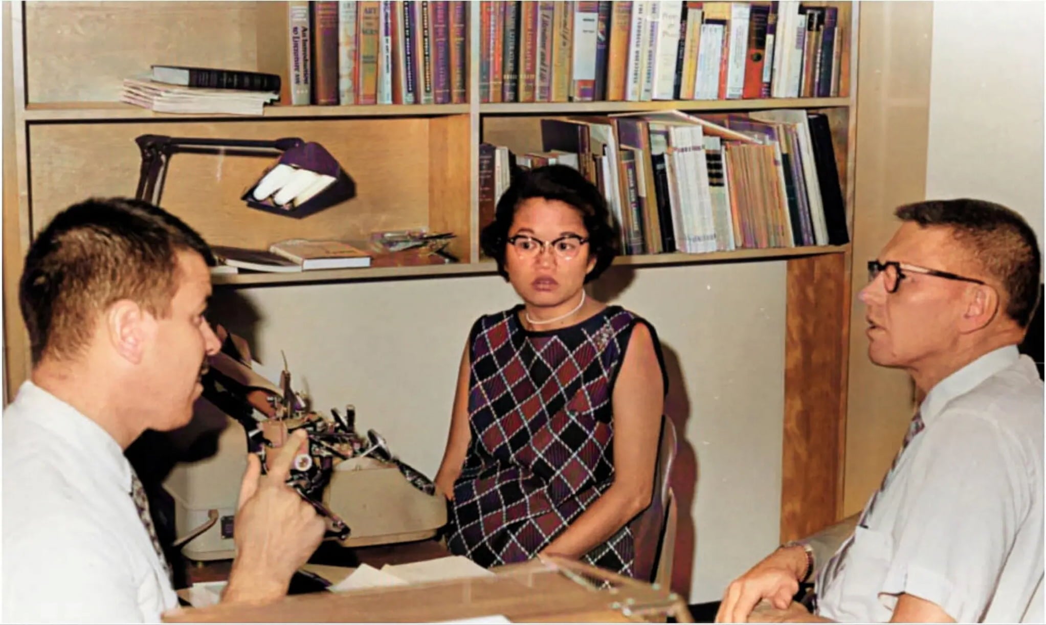 Dot has a conversation with two men in an office.