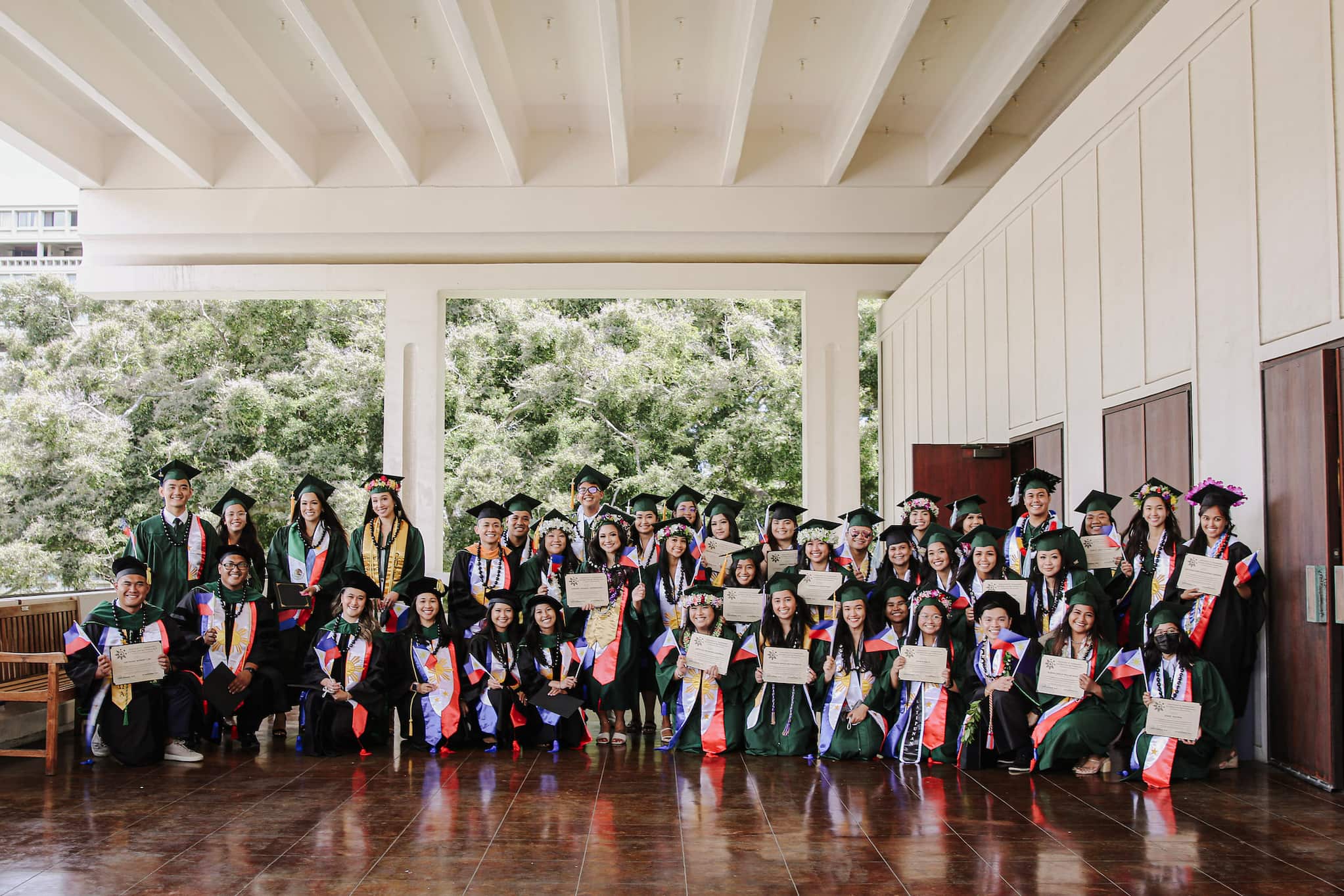 A graduating class of happy students posing in their caps and gowns.
