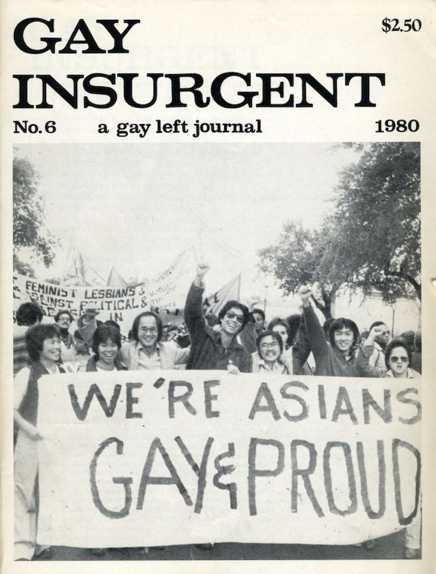 Proud, gay Asians hold banners at a march. People are smiling as they stand together. Some hold their fists in the air.