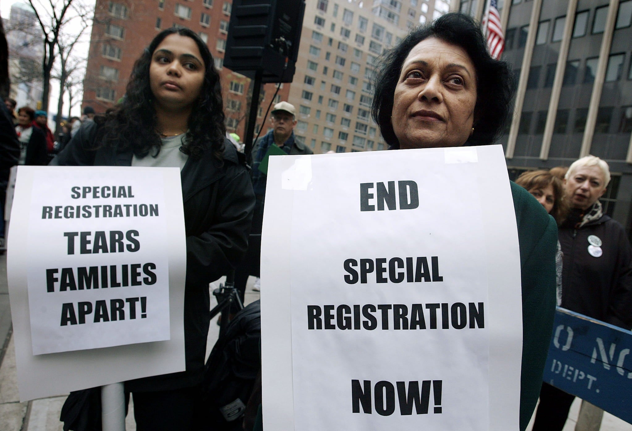 Two Muslim American women protest. They carry signs demanding an end to special registration for male non-citizens of Arab and Muslim countries.